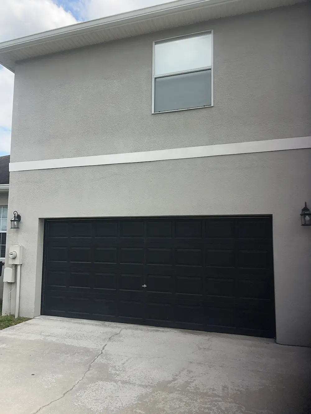 Two story stucco home clean after pressure washing.