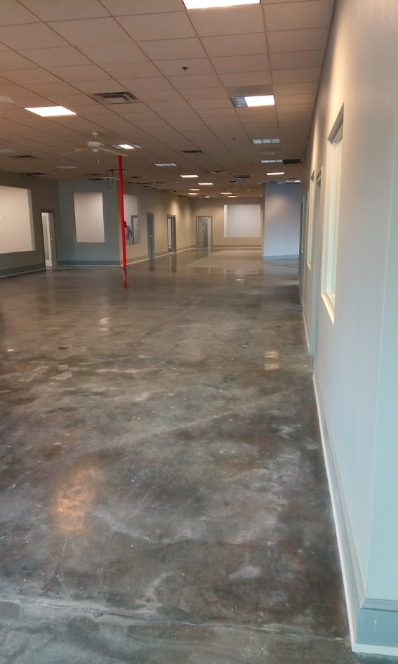 Interior view hallway view of multiple offices down a 100 foot wide hallway with polished floors.
