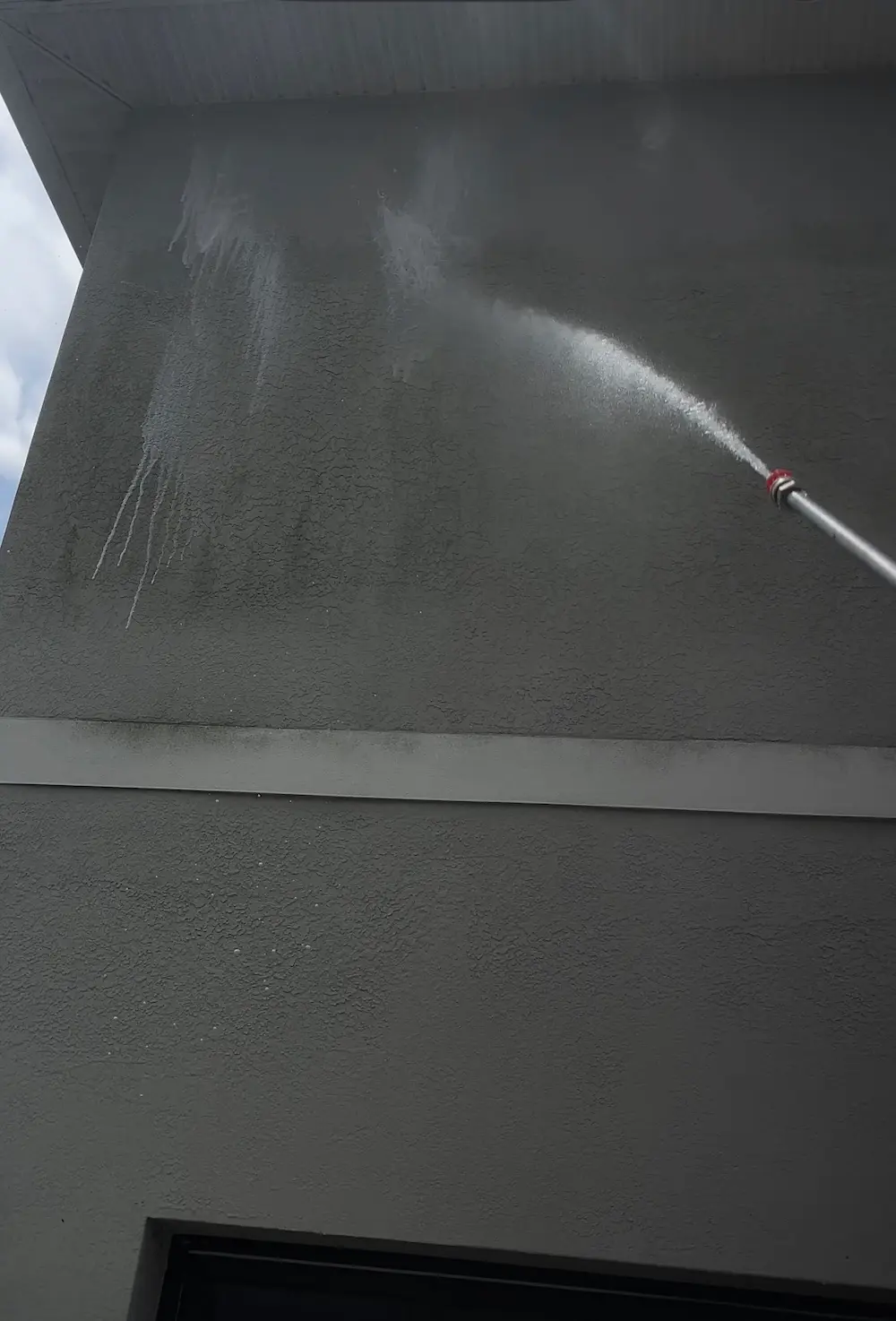 Two story stucco home clean after pressure washing.